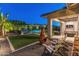 Inviting backyard with covered patio, fire pit, and pool area offering ample space for relaxation and entertainment at 11705 W Luxton Ln, Avondale, AZ 85323