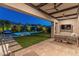 This backyard has a sparkling pool, a covered patio, and lush landscaping for privacy at 11705 W Luxton Ln, Avondale, AZ 85323