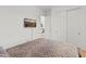 Cozy bedroom featuring neutral comforter, carpet, and tv mounted on wall at 11705 W Luxton Ln, Avondale, AZ 85323