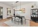 Bright dining room featuring modern light fixture, and white accent rug on light hardwood floors at 11705 W Luxton Ln, Avondale, AZ 85323