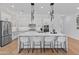 Modern kitchen featuring a large island with seating, stainless steel appliances, and stylish pendant lighting at 11705 W Luxton Ln, Avondale, AZ 85323