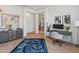 Bright office space with grey desk and chair, unique rug and hallway view at 11705 W Luxton Ln, Avondale, AZ 85323
