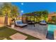 A serene poolside retreat featuring comfortable lounge furniture and lush landscaping at 11705 W Luxton Ln, Avondale, AZ 85323