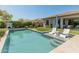 Inviting pool with in-water loungers, surrounded by lush landscaping and a serene backyard setting at 11705 W Luxton Ln, Avondale, AZ 85323