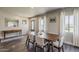 Well-lit dining room with a wooden table, seating for six, and views of the front yard through large windows at 1422 E Windsor Ave, Phoenix, AZ 85006