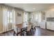 Bright dining room with a wooden table, six chairs, three windows with sheer curtains, and modern decor at 1422 E Windsor Ave, Phoenix, AZ 85006