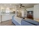 Open-concept living room featuring a blue sofa, modern ceiling fan, and seamless flow into the kitchen at 1422 E Windsor Ave, Phoenix, AZ 85006