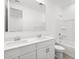 Bathroom featuring dual sinks, white cabinets and shower-tub combo with white tile at 35445 N Seedling St, San Tan Valley, AZ 85144