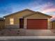 Inviting single-story home with a brick-lined driveway, a red garage door, and desert-friendly landscaping at 35445 N Seedling St, San Tan Valley, AZ 85144