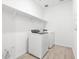 Bright laundry room with tile flooring, shelving, and washer and dryer at 35445 N Seedling St, San Tan Valley, AZ 85144