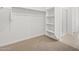 Bright walk-in closet with built-in shelving, rod, and an adjacent tiled shower room at 35445 N Seedling St, San Tan Valley, AZ 85144
