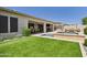 Lush backyard with pool, spa, outdoor kitchen, dining area, and synthetic grass at 4571 S Pinaleno W Dr, Chandler, AZ 85249