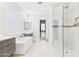 Bright bathroom with a soaking tub, glass shower and carrara marble mosaic tile flooring at 4571 S Pinaleno W Dr, Chandler, AZ 85249