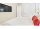 Bright bedroom with a TV, white bedding and a doorway to another room at 4571 S Pinaleno W Dr, Chandler, AZ 85249