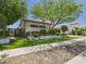 Beautifully landscaped home exterior with lush green trees, artificial turf, and stone planters at 4571 S Pinaleno W Dr, Chandler, AZ 85249