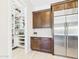 Pantry featuring custom shelving next to stainless steel refrigerator and freezer combo at 4571 S Pinaleno W Dr, Chandler, AZ 85249