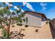 This backyard features desert landscaping, partial patio cover, and lush trees at 5750 S 250Th Dr, Buckeye, AZ 85326