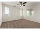 Bright bedroom featuring a ceiling fan, neutral carpet, and lots of natural light at 5750 S 250Th Dr, Buckeye, AZ 85326