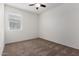 This is a cozy bedroom with neutral carpet, ceiling fan, and a window at 5750 S 250Th Dr, Buckeye, AZ 85326