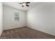 This bedroom features neutral carpet, a ceiling fan, and one window at 5750 S 250Th Dr, Buckeye, AZ 85326