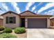 Charming single story home with a two car garage, low maintenance landscaping, and shuttered window accents at 5750 S 250Th Dr, Buckeye, AZ 85326