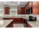 Well-lit kitchen features granite counters, stainless steel appliances, dark cabinetry, and a window over the sink at 5750 S 250Th Dr, Buckeye, AZ 85326
