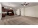Open floor plan with modern kitchen featuring granite countertops, stainless appliances, and wood-look tile flooring at 5750 S 250Th Dr, Buckeye, AZ 85326