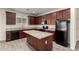 Stylish kitchen with granite counters, dark wood cabinets, black appliances, and a center island at 5750 S 250Th Dr, Buckeye, AZ 85326