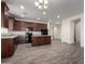 Modern kitchen features dark wood cabinets, granite countertops, stainless appliances, and an adjoining living space at 5750 S 250Th Dr, Buckeye, AZ 85326