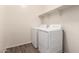 This is a laundry room with laminate flooring, storage shelves and a white washer and dryer at 5750 S 250Th Dr, Buckeye, AZ 85326