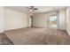 Spacious living room with plush carpeting, a ceiling fan, and sliding glass doors to the outdoor space at 5750 S 250Th Dr, Buckeye, AZ 85326