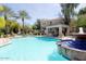 Community pool with a water feature, palm trees, lounge chairs, and shaded seating area at 11375 E Sahuaro Dr # 1107, Scottsdale, AZ 85259