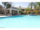 Resort style community pool with covered patio, chairs, and outdoor seating at 11375 E Sahuaro Dr # 1107, Scottsdale, AZ 85259