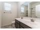 Bright bathroom showcasing dual sinks, gray cabinetry, a large mirror, and a shower at 12474 W Glenn Ct, Glendale, AZ 85307