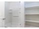 All-white bathroom with a bathtub and shower, and built-in storage shelving at 12474 W Glenn Ct, Glendale, AZ 85307