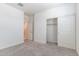 Spacious bedroom featuring neutral carpet, closet, and attached bathroom access at 12474 W Glenn Ct, Glendale, AZ 85307