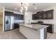 Bright kitchen features granite counters, subway tile backsplash, stainless appliances and stylish pendant lighting at 12474 W Glenn Ct, Glendale, AZ 85307