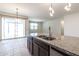 Kitchen island with stainless steel sink and faucet overlooks the living area and outdoor patio access at 12474 W Glenn Ct, Glendale, AZ 85307