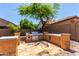 Built in outdoor kitchen with stone countertops, sink, grill and desert landscaping at 12957 W Scotts Dr, El Mirage, AZ 85335