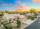 Stunning desert home featuring a three-car garage, mature landscaping, and neutral colors under a colorful sunset sky at 14999 W Mulberry Dr, Goodyear, AZ 85395