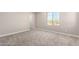 Bright bedroom with neutral-toned carpet and large window offering neighborhood views at 15622 S 181St Dr, Goodyear, AZ 85338