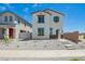 A two-story white home featuring brown trim, a green door, minimal landscaping, and a welcoming concrete path at 15622 S 181St Dr, Goodyear, AZ 85338
