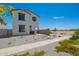 Two-story home with white exterior, brown trim, green door, minimal landscaping, and a concrete pathway at 15622 S 181St Dr, Goodyear, AZ 85338