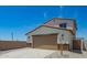 Charming home exterior featuring a large garage, manicured landscaping, and a concrete driveway at 15622 S 181St Dr, Goodyear, AZ 85338