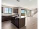 Open kitchen with dark wood cabinets, granite counters, stainless appliances, island, and tile floors at 15622 S 181St Dr, Goodyear, AZ 85338