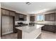 Charming kitchen features granite countertops, an island with seating, and stainless steel appliances at 15622 S 181St Dr, Goodyear, AZ 85338