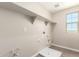 Functional laundry room features shelving, window, and essential utility connections at 15622 S 181St Dr, Goodyear, AZ 85338