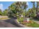 Inviting entry to a gated community with lush landscaping, manicured lawns and decorative street signage at 2425 E Oregon Ave, Phoenix, AZ 85016