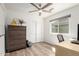 Cozy bedroom features closet, wood floors, ceiling fan, and natural light from a bright window at 3269 E San Remo Ave, Gilbert, AZ 85234