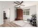 Bright bedroom features wood floors, ceiling fan, large armoire, and cozy chair with natural light at 3269 E San Remo Ave, Gilbert, AZ 85234